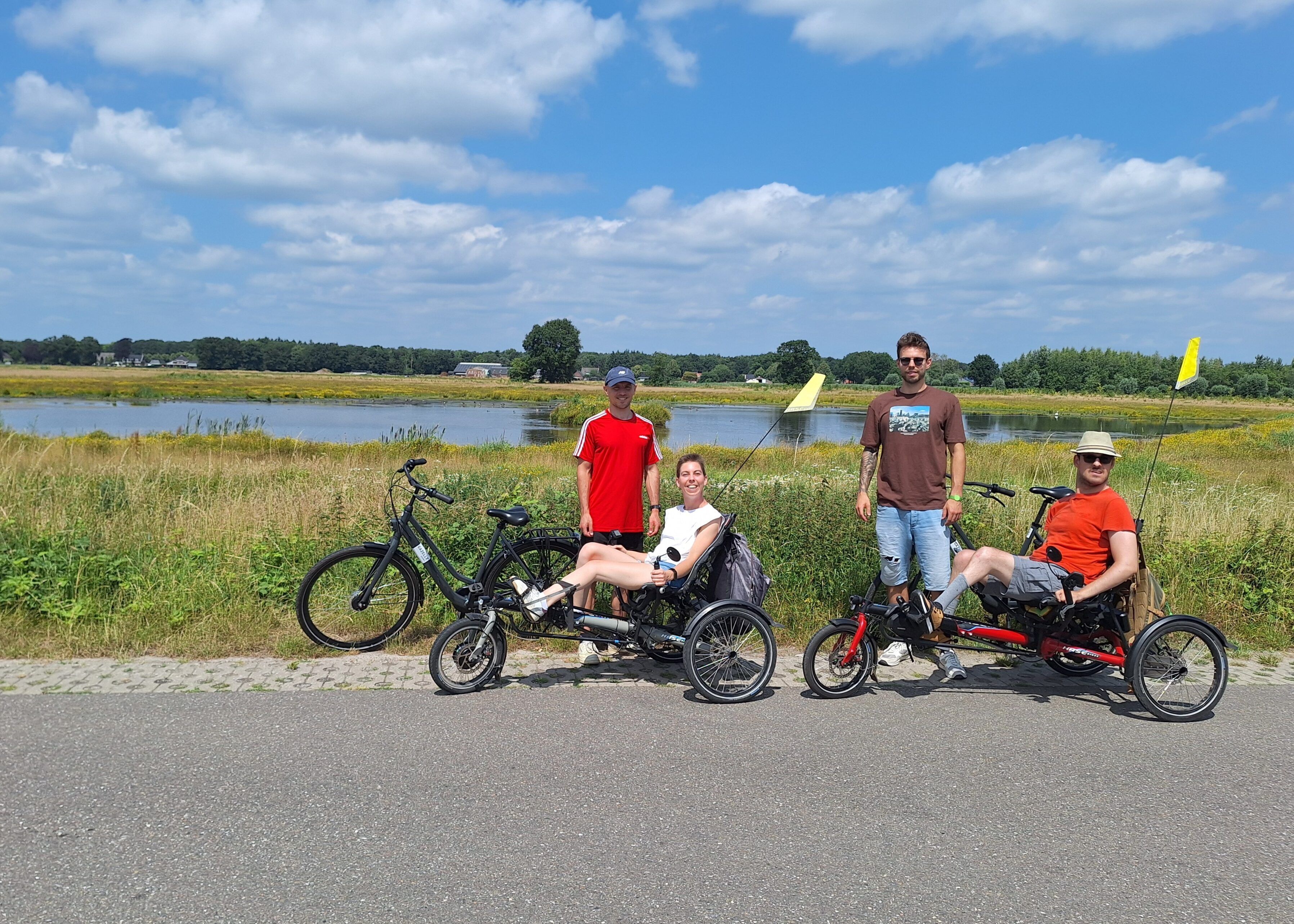 Fien en Jonas op hun fietsen met assistenten Axel en Jerome
